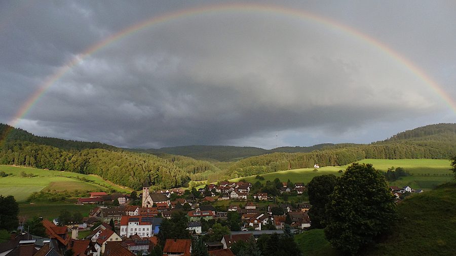 Dörlinbach im Schuttertal unter einem Regenbogen, umgeben von Schwarzwaldlandschaft