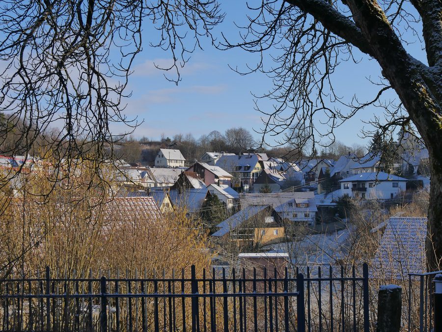 Blick von der Brücke zwischen Kirche und Pfarrhaus in Richtung Fluorner Rathaus